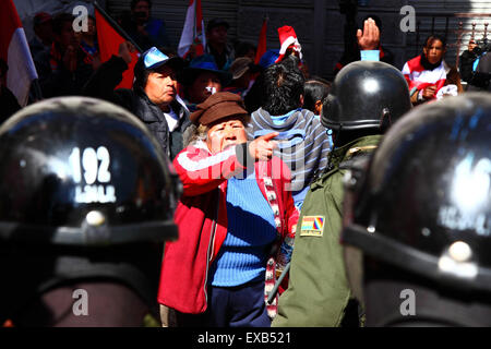 La Paz, Bolivia, 10th July 2015. A protestor from the Potosi area confronts riot police during a protest by the Potosi Civic Committee and supporters. The protestors are in La Paz to demand the government keeps electoral promises made to the region in the past. Credit:  James Brunker / Alamy Live News Stock Photo