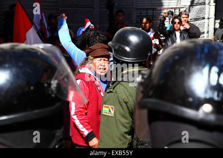 La Paz, Bolivia, 10th July 2015. A protestor from the Potosi area confronts riot police during a protest by the Potosi Civic Committee and supporters. The protestors are in La Paz to demand the government keeps electoral promises made to the region in the past. Credit:  James Brunker / Alamy Live News Stock Photo