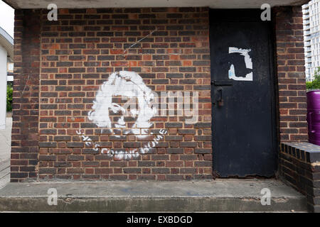 'She's Coming Home' stencil graffiti at the base of the Clock Tower at Chrisp Street Market, Poplar, London, England, UK. Stock Photo