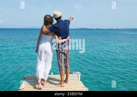 Couple looking at the sea from a dock Stock Photo