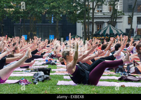 New York City, USA; 09 July 2015: People participating in the free public Yoga class on Thursday evenings in summer at Bryant Park, New York City. Credit:  Priyanka Madia/Alamy Live News Stock Photo