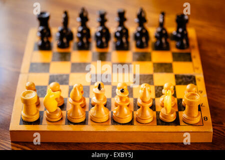 Chess standing on ancient wooden chessboard Stock Photo