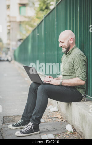 handsome middle aged man using notebook in the city Stock Photo