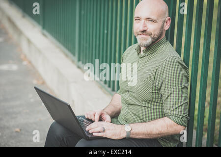 handsome middle aged man using notebook in the city Stock Photo