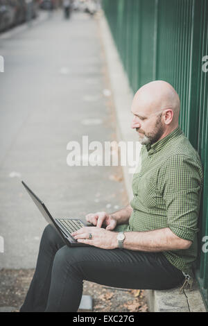 handsome middle aged man using notebook in the city Stock Photo