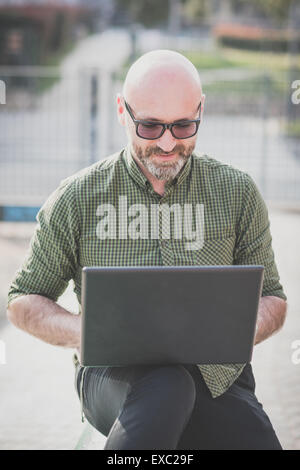 handsome middle aged man using notebook in the city Stock Photo