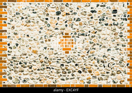 A renovated flint stone wall with modern red bricks Stock Photo