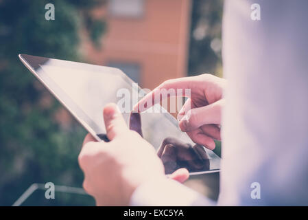 close up hands multitasking man using tablet connecting wifi Stock Photo