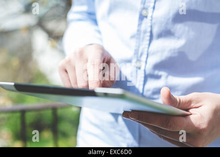 close up hands multitasking man using tablet connecting wifi Stock Photo