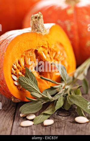 Pumpkins whole and cut with fresh sage Stock Photo