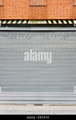 Part of an industrial metal door with a headroom warning Stock Photo