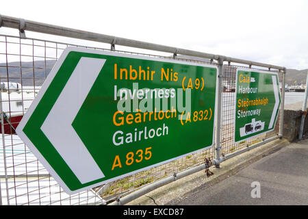 UK road directions signs in Ullapool, Scottish Highlands, promoting Gaelic over English Stock Photo