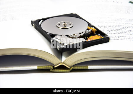 hard disk on the book  to show the importance of dematerialize Stock Photo
