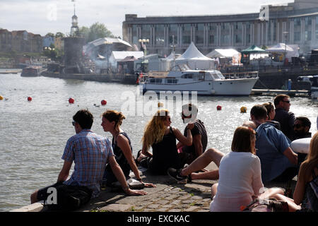 Smoke from 'Grillstock' fills the air whilst people relax and enjoy the sunshine at the Arnolfini in Bristol, UK Stock Photo