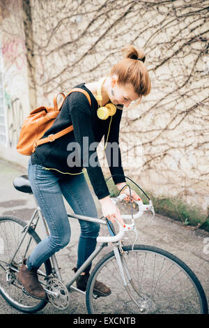 young beautiful hipster sporty blonde woman in town with bike Stock Photo