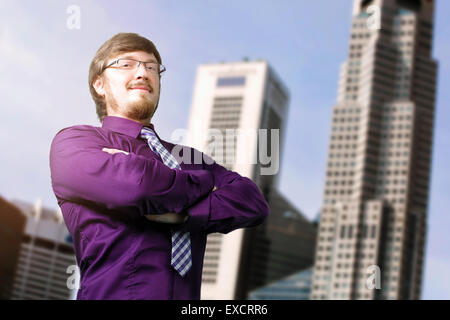 Portrait of a young smiling businessman crossing his hands Stock Photo