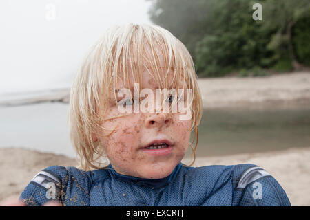 A four year old boy wearing a Captain America costume plays on a sandy beach at Lake Michigan. Stock Photo