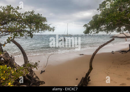 Sailboat and fishing boat anchored behind the protective wall of a rocky reef at Tayrona National Park near Santa Marta, Colombi Stock Photo