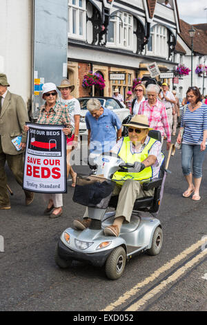 Henley-on-Thames, UK. 11th July, 2015. An elderly disabled man on a mobility scooter takes part in a demonstration with other protesters carrying placards for the 'Save Our Beds' campaign in a peaceful protest march in Henley-on-Thames, Oxfordshire, England, on Saturday 11 July 2015 against the Oxfordshire Clinical Commissioning Group's plans for its new health campus, Townlands Hospital.  The new hospital was originally planned to have 18 beds, now changed to 5 beds in a care home to be built next to the hospital Credit:  Graham Prentice/Alamy Live News Stock Photo