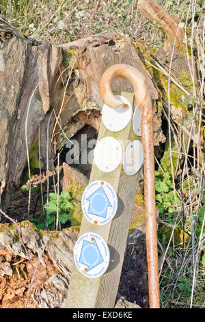 Shepherd's crook walking stick resting against a public bridleway post Stock Photo