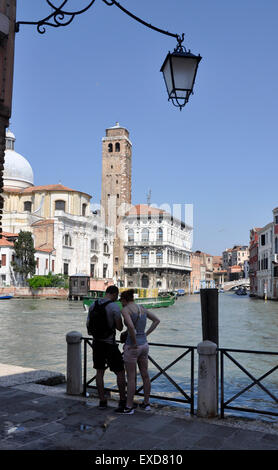 Italy Venice Canale Grande Santa Croce region - young couple - guide book check - opposite San Geremia sun+ blue sky Stock Photo