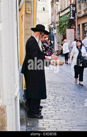 Two orthodox jewish men reading Torah, asking for donations in the Jewish quarter, Le Marais, Paris, France. Stock Photo