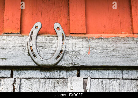 A Black Painted Horseshoe on Barn Wall Stock Photo