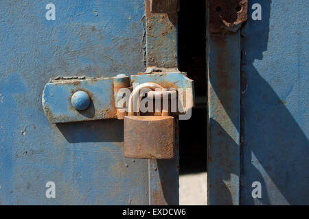 old door with blue chipped paint and rusted padlock Stock Photo