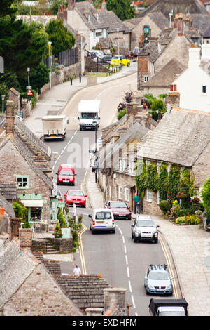 Typical English village of Corfe in Dorest. Main narrow two lane main street winding it way through and up and down the village. Some traffic. Daytime.
