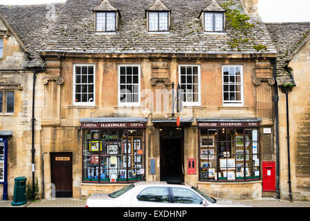 English Cotswold town, Chipping Campden. High Street, front exterior of terrace double-fronted stone building, post office, with red post box on end. Stock Photo