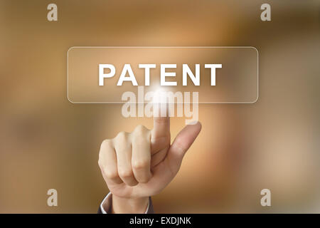 business hand pushing patent button on blurred background Stock Photo
