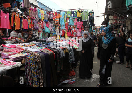 Jabalia, The Gaza Strip, Palestine. 12th July, 2015. Palestinian buy new clothes for Eid Al Fitr from Jabalia refugee camp market northern the Gaza Strip. © Mahmoud Issa/Quds Net News/ZUMAPRESS.com/Alamy Live News Stock Photo