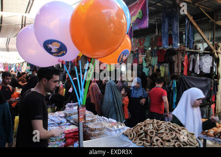 Jabalia, The Gaza Strip, Palestine. 12th July, 2015. Palestinian buy new clothes for Eid Al Fitr from Jabalia refugee camp market northern the Gaza Strip. © Mahmoud Issa/Quds Net News/ZUMAPRESS.com/Alamy Live News Stock Photo