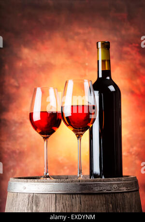 Bottle of red wine and two glasses filled with a wooden barrel Stock Photo