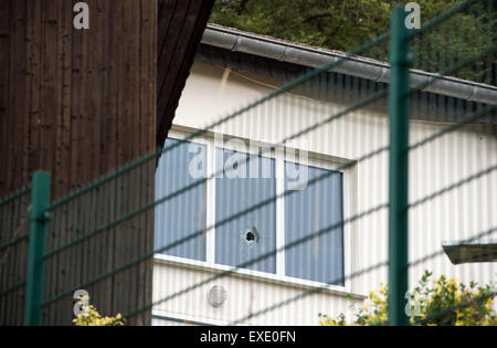 Marsberg, Germany. 12th July, 2015. A hole in a window of the hall at the marksmen association in Marsberg, Germany, 12 July 2015. A man was hit and a window was smashed by a metal part of a cannon on 11 July 2015. The cannon barrel burst during a firing of the cannon, which hit a champion marksman and smashed a window. The champion marksman was killed in the incident. Photo: BERND THISSEN/dpa/Alamy Live News Stock Photo