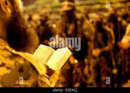 Gaza, Palestine. 12th July, 2015. Militants from al-Nasser Salah al-Deen Brigade, the military wing of the Popular Resistance Committees march during an anti-Israel rally marking the first anniversary of the 50-day Israeli war on Gaza Strip last summer. © Nidal Alwaheidi/Pacific Press/Alamy Live News Stock Photo