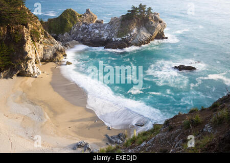 Waterfall in Julia Pfeifer Burns State Park at sunset with a soft golden color on the rocks Stock Photo