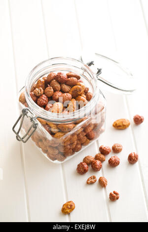 various sugared nuts in jar on kitchen table Stock Photo