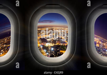 City at night through airplane window Stock Photo