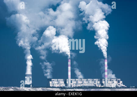 big factory with smoky chimneys and blue sky Stock Photo