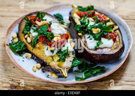 Roast aubergine with goat cheese, crispy kale, sun dried tomatoes and pine nuts Stock Photo