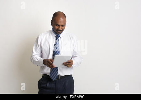 indian business male smiling while using a tablet Stock Photo
