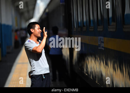 Lanzhou, China's Gansu Province. 13th July, 2015. A man waves goodbye on a platform of Lanzhou Railway Station in Lanzhou, capital of northwest China's Gansu Province, July 13, 2015. Lanzhou Railway Station recently witnessed its first travel peak this summer. © Chen Bin/Xinhua/Alamy Live News Stock Photo