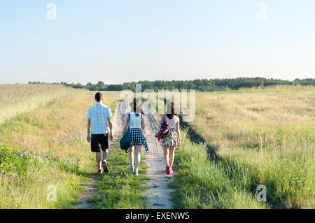 Young people walking away along country path Stock Photo