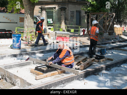 Men working on new tram tracks within Montpellier,  Hérault , Languedoc-Roussillon, France, Europe Stock Photo