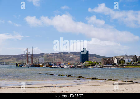 View across Leodamais Bay to moored boats in harbour from beach in Port Ellen, Isle of Islay, Inner Hebrides, Scotland, UK Stock Photo