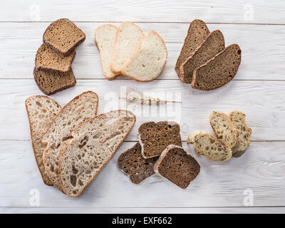 Different types of sliced bread on wooden table. Stock Photo
