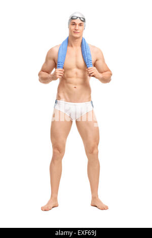 Full length portrait of a young man in white swim trunks carrying a towel around his neck and looking at the camera Stock Photo