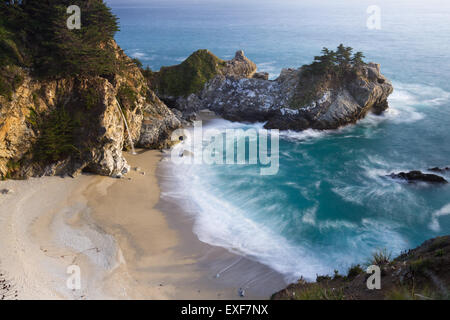 Waterfall in Julia Pfeifer Burns State Park at sunset with a soft golden color on the rocks Stock Photo