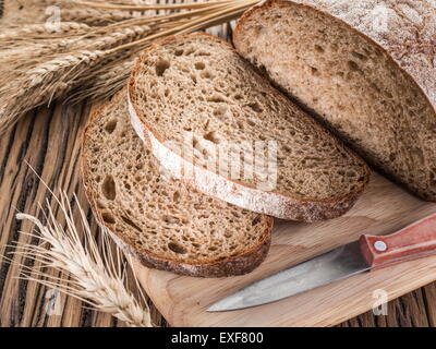 Sliced black bread on the old wooden plank. Stock Photo